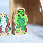 Lanka Kade hermit and green troll wooden toy figures placed on a carpeted surface.