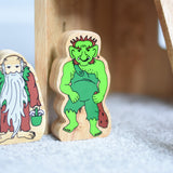 Lanka Kade hermit and green troll wooden toy figures placed on a carpeted surface.