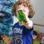 A close up of the green Lanka Kade troll character figure in a child's hand.