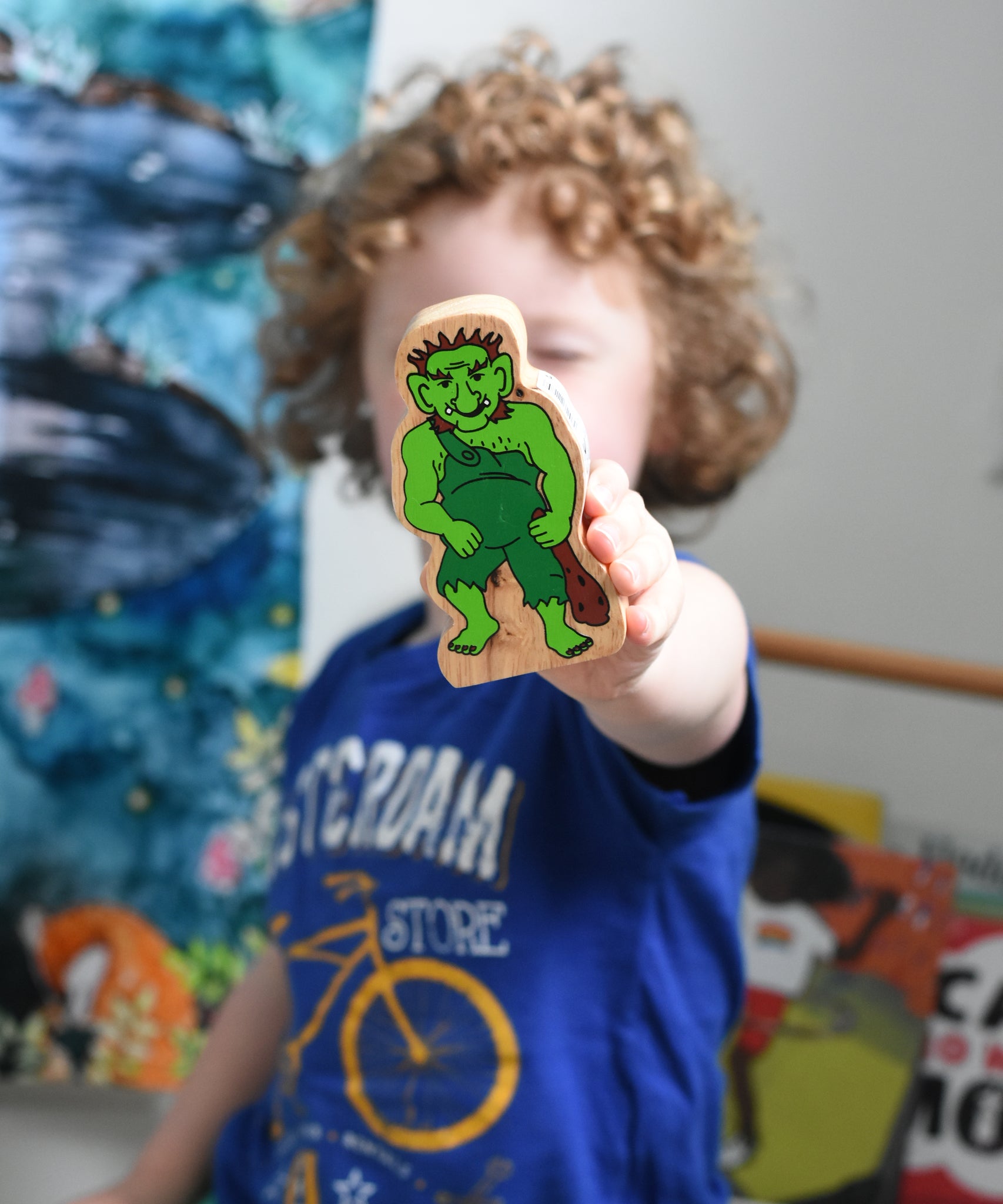 A close up of the green Lanka Kade troll character figure in a child's hand.