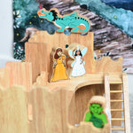 Lanka Kade princess and airy figures standing on the upper floor of the Lanka Kade Castle. A green dragon figure has been placed on top of the castle walls behind them. A green troll figure can be seen blurred out in the foreground.