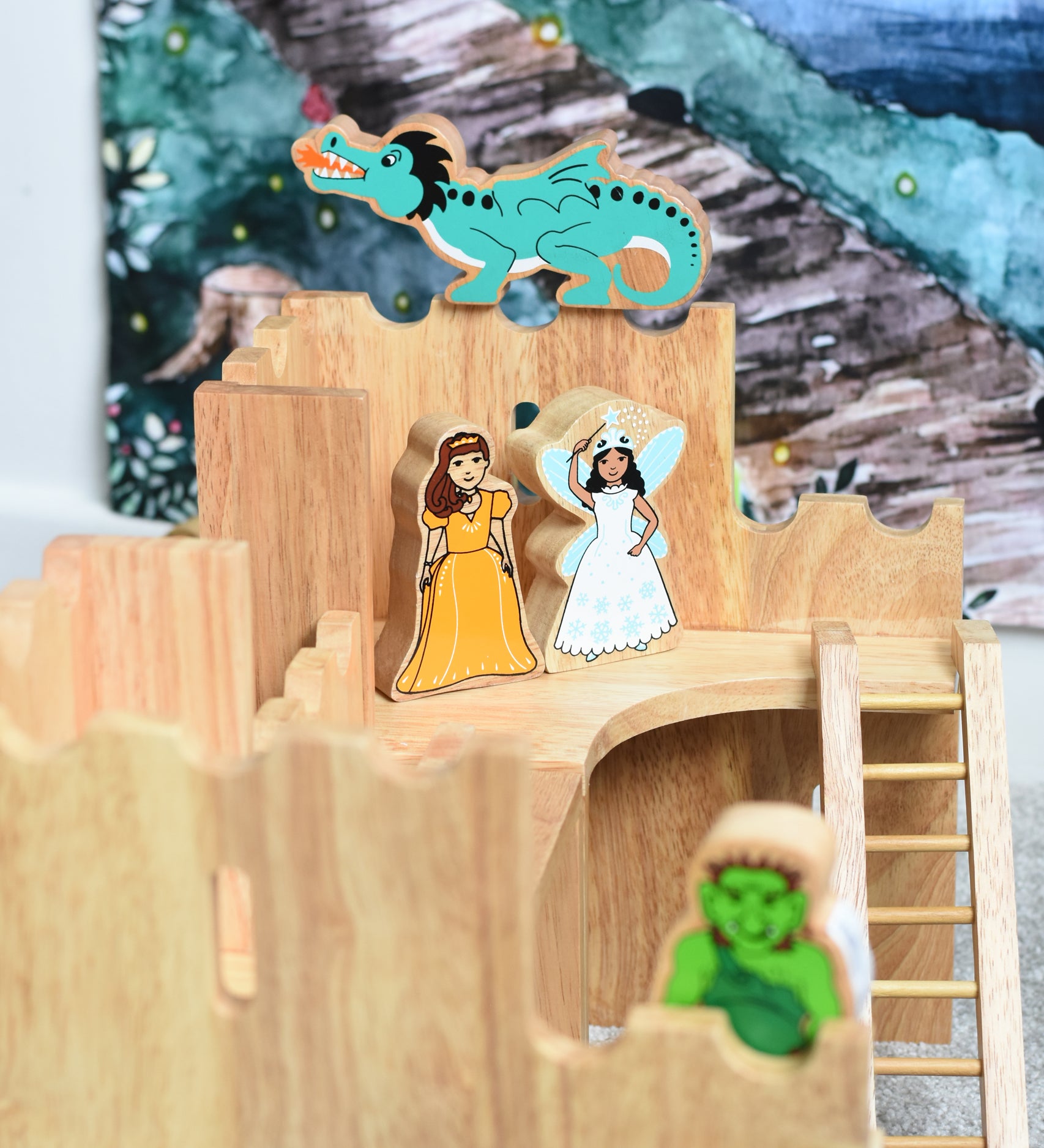 Lanka Kade princess and airy figures standing on the upper floor of the Lanka Kade Castle. A green dragon figure has been placed on top of the castle walls behind them. A green troll figure can be seen blurred out in the foreground.