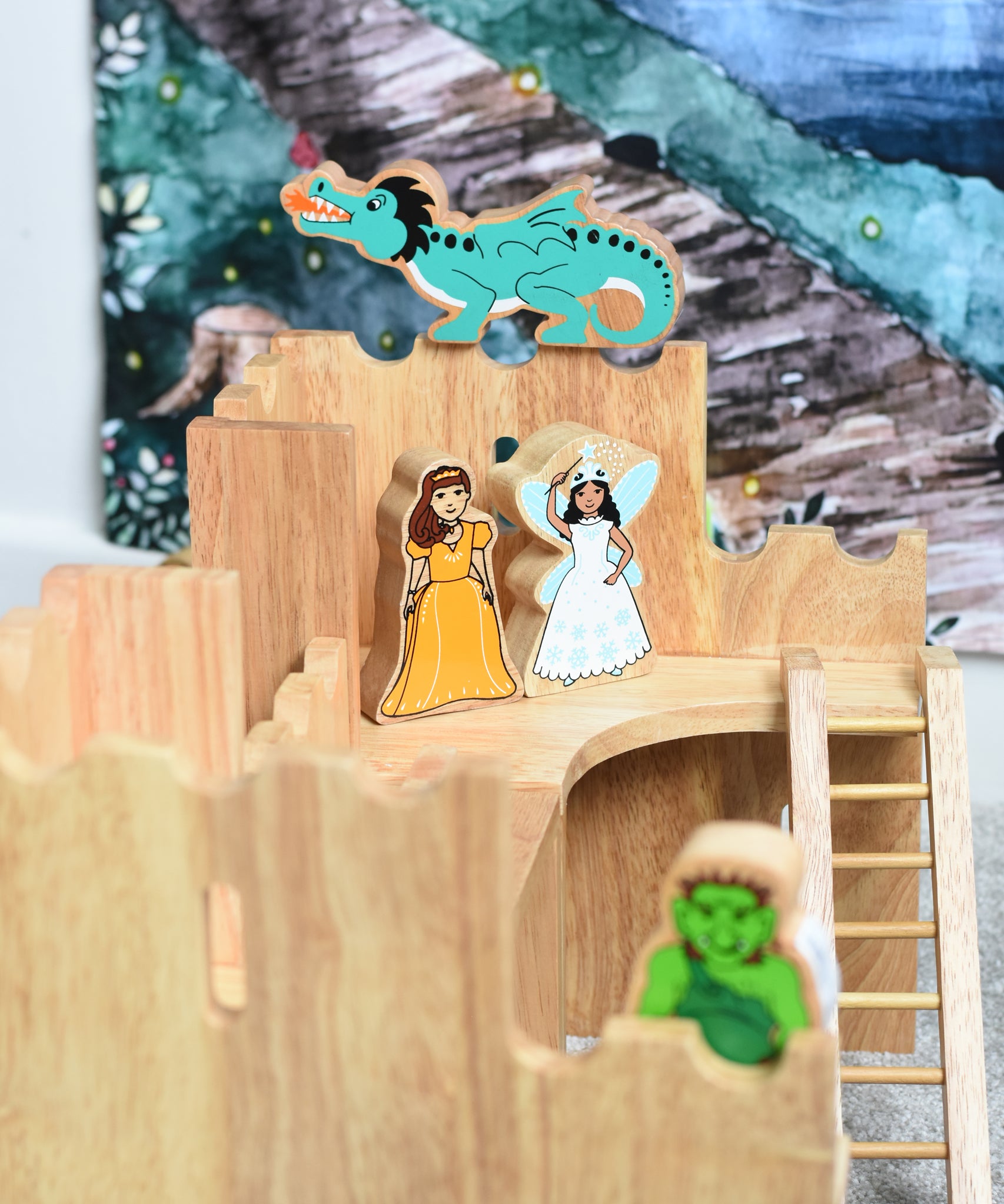 Lanka Kade princess and airy figures standing on the upper floor of the Lanka Kade Castle. A green dragon figure has been placed on top of the castle walls behind them. A green troll figure can be seen blurred out in the foreground.