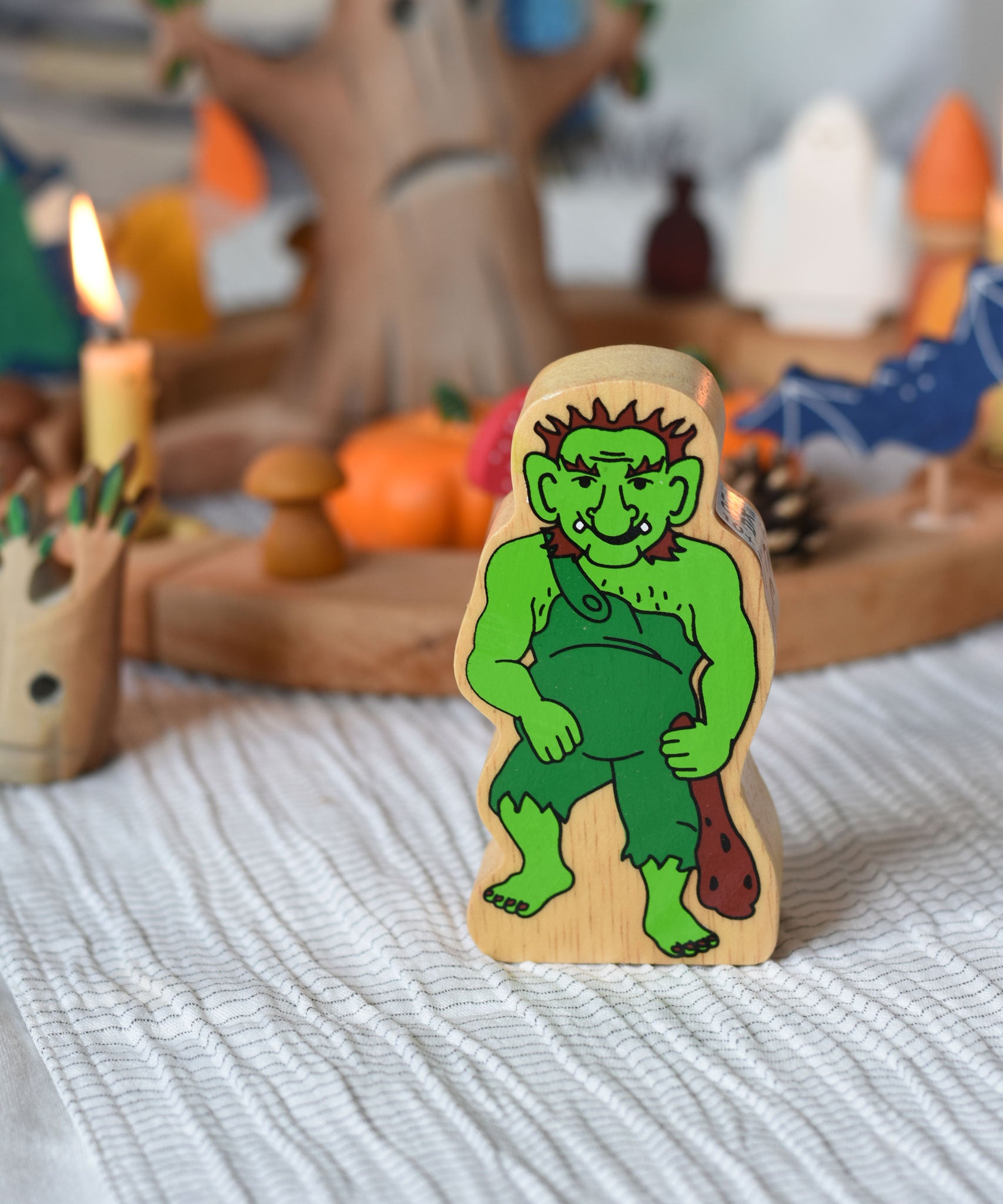 A Lanka Kade wooden troll figure placed in front of an Autumnal Halloween themed celebration ring set up. 