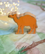A Lanka Kade camel wooden toy figure placed on a Wonderie play cloth. These wooden toy figures are part of a huge range of Lanka Kade fair trade, wooden toys available here at Babipur.