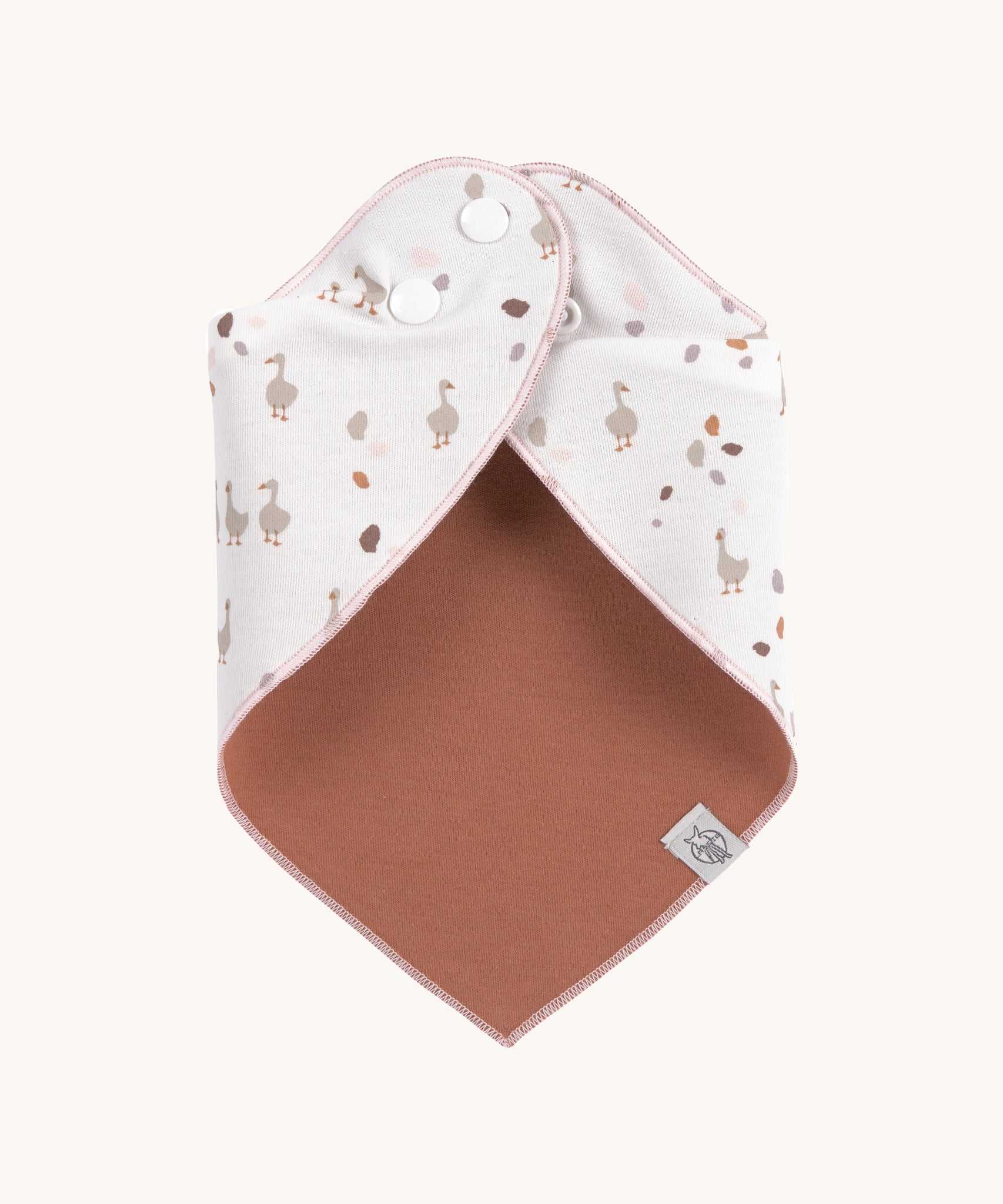 The Lassig goose dribble bib for babies, fastened with poppers at the neck. 