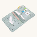 The Lassig baby changing pouch made from 100% recycled polyester, in a floral mint green pattern, opened to show the pockets and compartments.