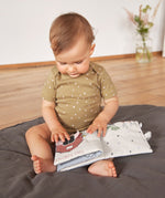 A little baby touching the Lassig Baby Touch & Feel soft toy book.