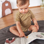 A littler baby touching the Lassig Baby Touch & Feel soft toy book.