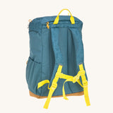 The back of the Lassig kids big outdoor backpack in Adventure Blue, with a coat secured under the front strap. These children's backpacks are part of a wide range available at Babipur.