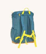 The back of the Lassig kids big outdoor backpack in Adventure Blue, with a coat secured under the front strap. These children's backpacks are part of a wide range available at Babipur.