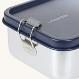 The clap closure on the Lassig Stainless Steel Lunchbox with a Unique Dark Blue lid. This lunch box has a removable divider. 