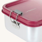 A close up of the clasp closure on the Lassig Stainless Steel Lunchbox in a Unique Berry Rose colour. This stainless steel lunch box has a removable divider.
