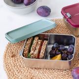 A Lassig Stainless Steel Lunchbox in the Unique Olive Green colour. The divided lunchbox is shown filled with food.
