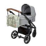 The Lassig every day change nappy bag in light khaki attached to a pram with the included hooks.