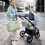 A woman with a pram and the Lassig every day change nappy bag in light khaki.