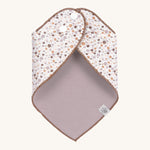 The Lassig floral dribble bib for babies, fastened with poppers at the neck. 