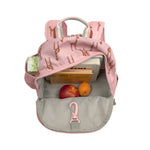 The Lassig kids mini backpack in a Safari Giraffe pink print, with the main zip opened to show how you can store books and snacks inside, as well as a juice box in the mesh side bottle holder. 