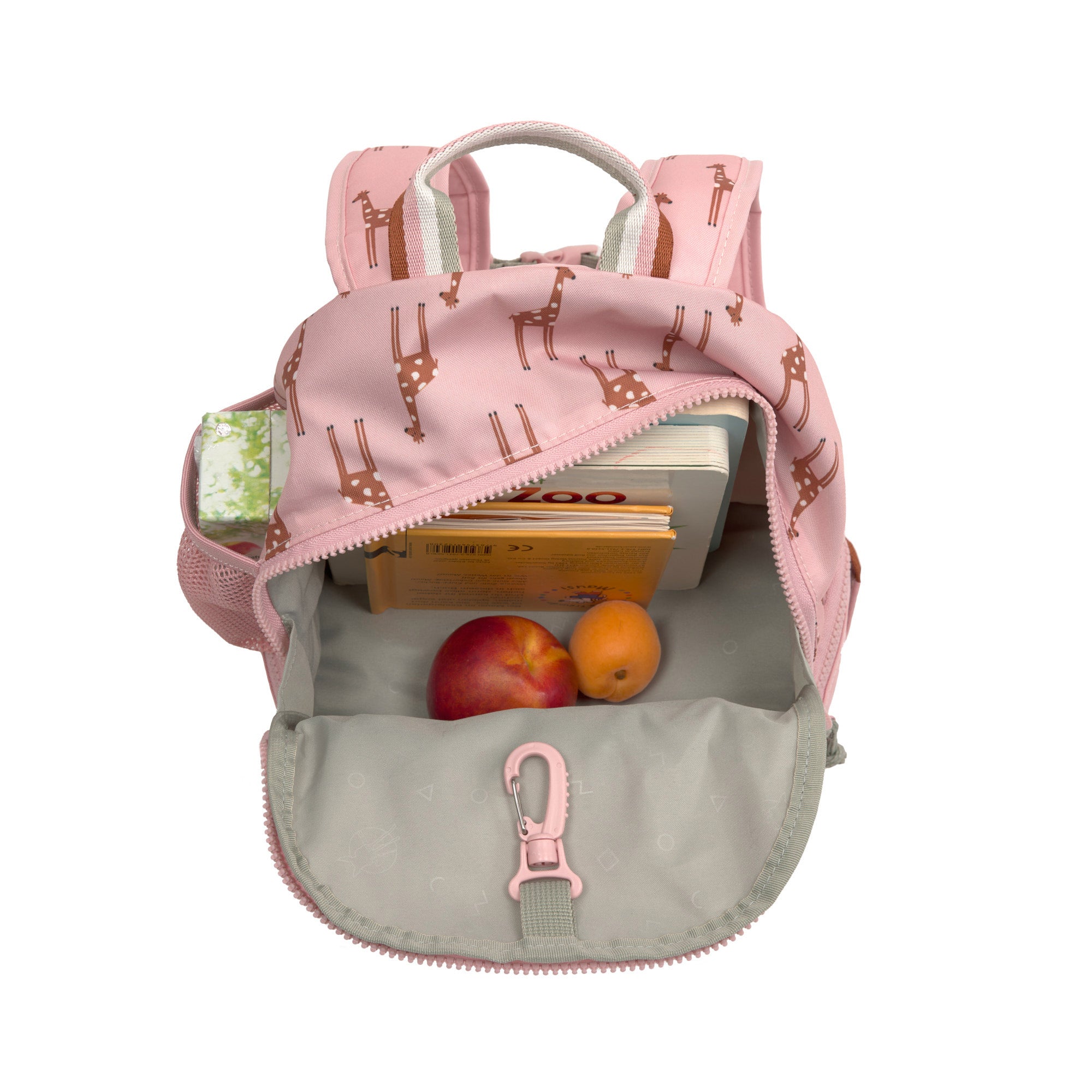 The Lassig kids mini backpack in a Safari Giraffe pink print, with the main zip opened to show how you can store books and snacks inside, as well as a juice box in the mesh side bottle holder. 