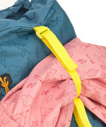 The Lassig kids big outdoor backpack in Adventure Blue, with a coat secured under the front strap. These children's backpacks are part of a wide range available at Babipur.