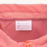 A close up of the name and details tag inside the Lassig Kids Big Outdoor Backpack with an Adventure rose pink design. The print features tents, trees, and clouds, and a pink front strap. These children's backpacks are part of a wide range available at Babipur.