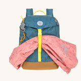The Lassig kids big outdoor backpack in Adventure Blue, with a coat secured under the front strap. These children's backpacks are part of a wide range available at Babipur.