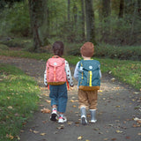 Two children walking next to each other, each are wearing a Lassig Kids Big Outdoor Backpack, one in a rose pink colour and the other in a blue colour. 
These children's backpacks are part of a wide range available at Babipur.