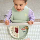 A child using the Lassig Cutlery with Silicone Handle  featuring Happy Fruits Lemon design. This children's cutlery set is part of a wide range of tableware available at Babipur.