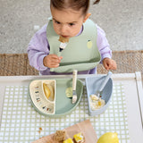 A child using the Lassig Cutlery with Silicone Handle  featuring Happy Fruits Lemon design. This children's cutlery set is part of a wide range of tableware available at Babipur.