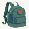 The Lassig mini backpack for kids in a dark green colour, with blue zips and a smiley face patch.