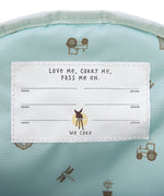 A closeup of the 'pass-me-on' name label inside the Lassig Kids mini backpack, with multiple spaces for kids to hand the bag down to younger siblings. 