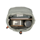 A top view of the Lassig kids mini outdoor backpack in blue, showing the inside capacity with a lunchbox, water bottle, and books inside.