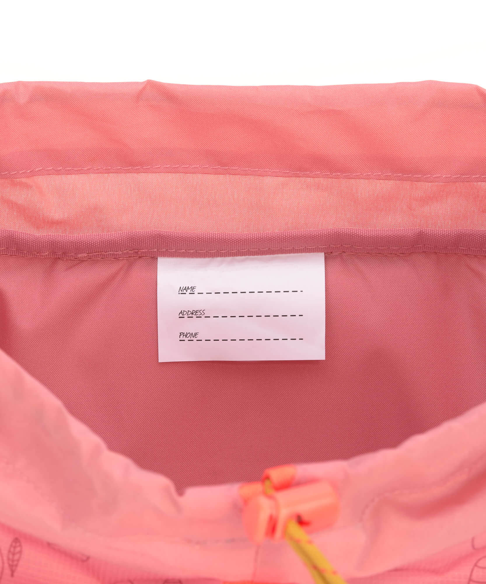 A close up of the name tag for the Lassig kids mini adventure backpack in rose.