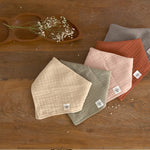 Five different coloured Lassig muslin dribble bibs.