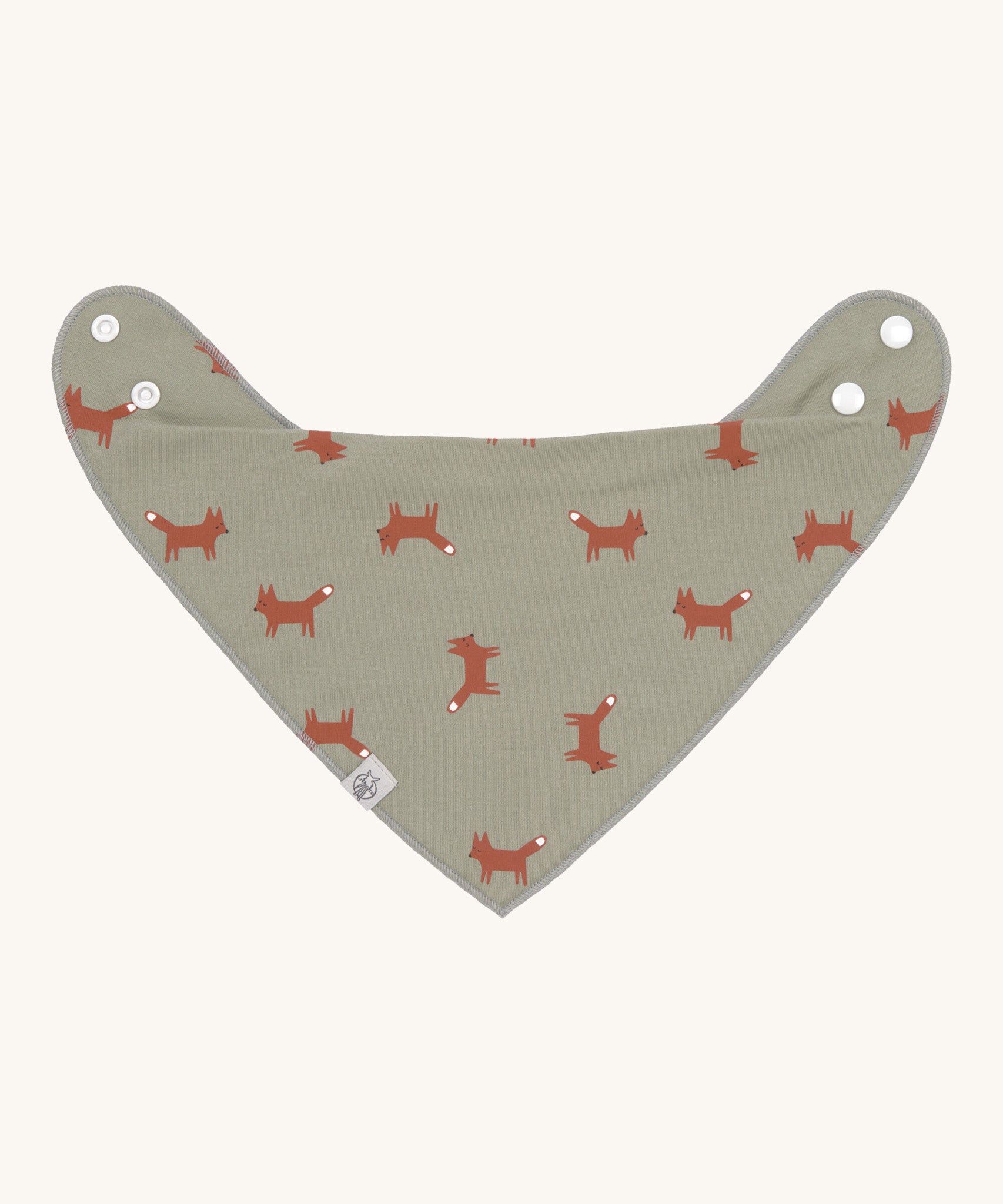 The Lassig organic cotton bandana dribble bib, in a soft green colour with little foxes printed all over. It has white popper fastenings. 