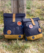 Lassig Medium Rolltop Backpack in a Little Gang Navy colour design shown next to a mini size. These roll top bags are available in different colours and sizes at Babipur.