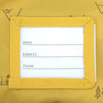 The name label on the inside of the Lassig kids mini campervan backpack, with a yellow lining with a campervan pattern. 