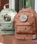 Lassig kids mini party caramel and olive pattern backpacks outside on a step. Features padded shoulder straps, mesh side pockets, a handy loop handle on the top and 3 zipped compartments. 