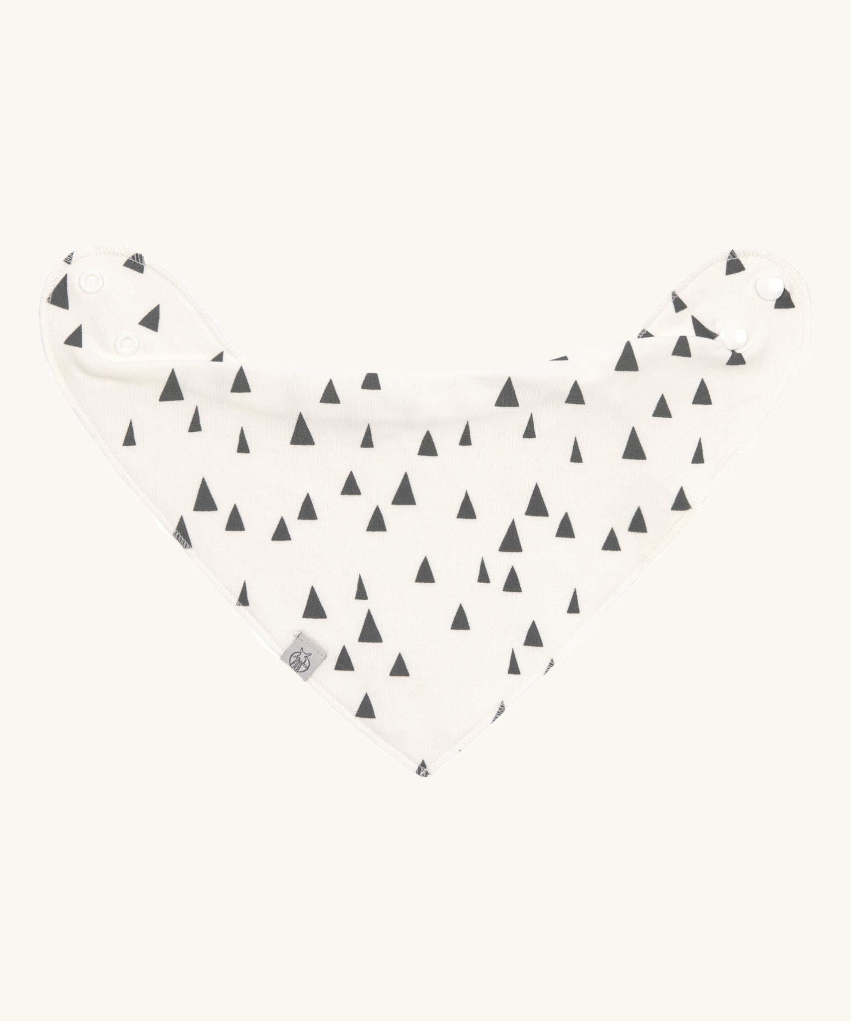The Lassig organic cotton bandana dribble bib, in white with little grey triangles printed all over. It has white popper fastenings. 