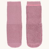The Lassig organic cotton baby and toddler anti-slip grippy socks, one is inside out to show the fluffy inside.