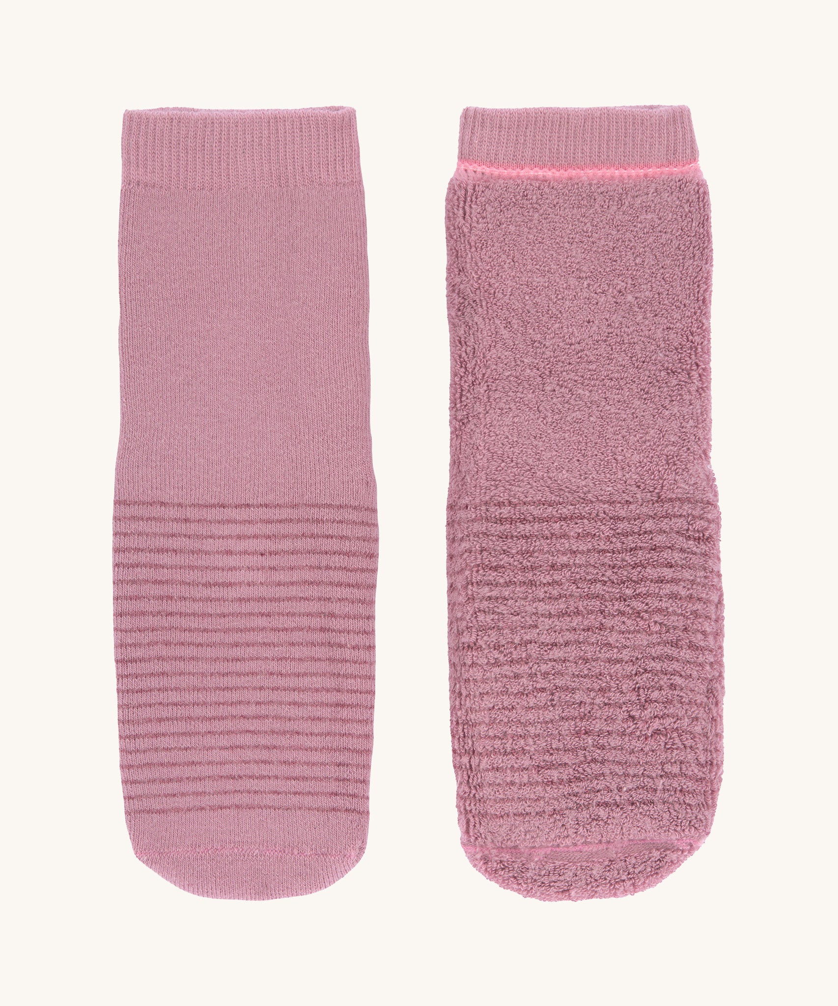 The Lassig organic cotton baby and toddler anti-slip grippy socks, one is inside out to show the fluffy inside.