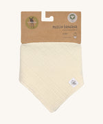The Lassig organic cotton muslin bandana dribble bib, in a creamy Vanilla colour, attached to it's cardboard label. 