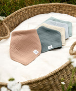 A basket full of different coloured Lassig Bandana Dribble Bibs. 