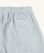 A closeup of the back pocket on the Lassig organic cotton muslin baby pants, in powder blue. 