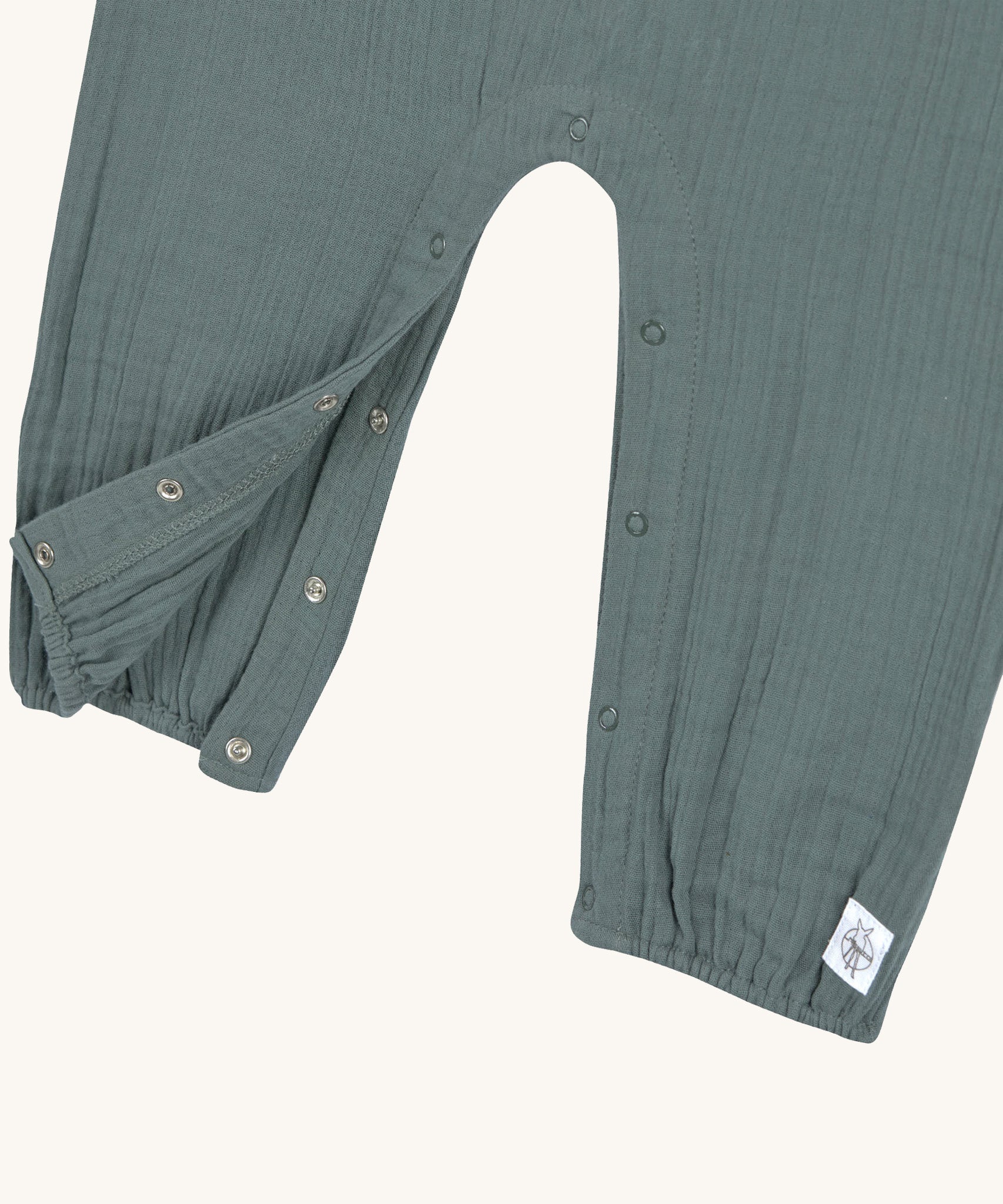 A closeup of the push-snap fastenings around the crotch and leg area, for easy dressing. 