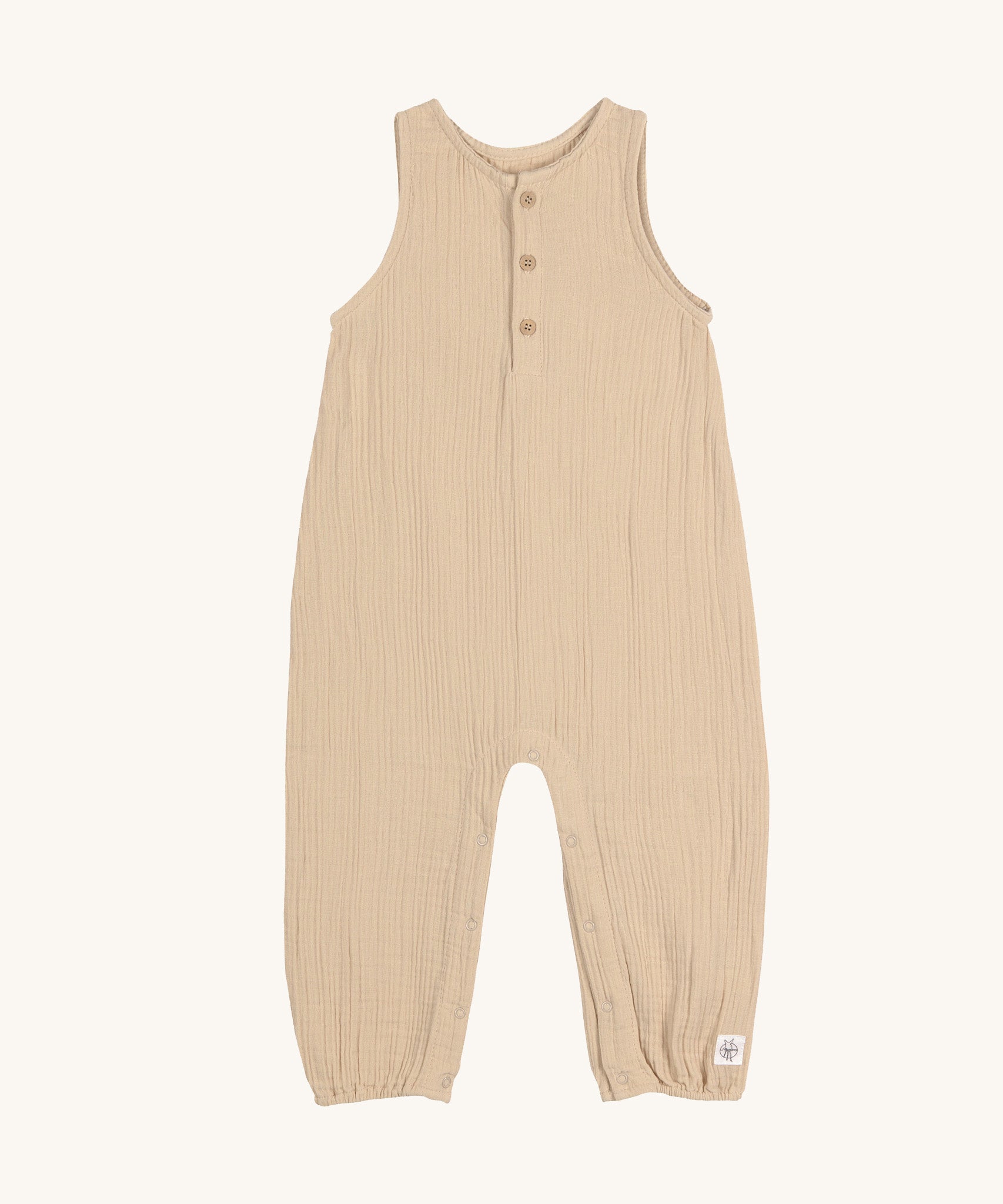 The Lassig organic cotton muslin baby and toddler jumpsuit in a natural cream colour, with little cream buttons at the neck.