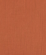 A closeup of the lovely organic cotton muslin fabric in orange rust. 