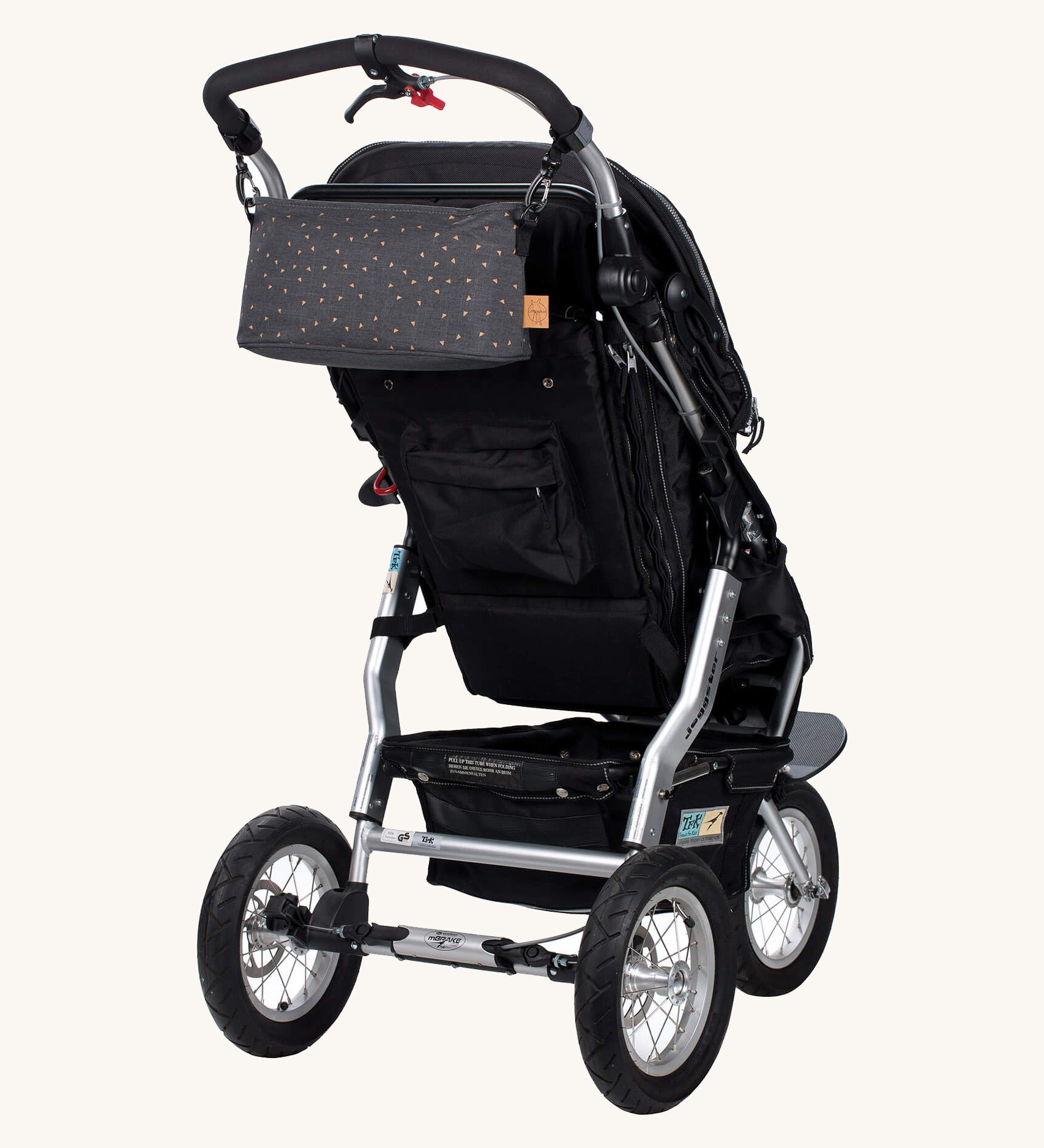The Lassig buggy pram organiser bag in triangle grey, attached to a pram with the included hook clips.