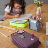 Lassig kids spacy school pencil case in purple on a wooden desk with cute patches and a clip on the elastic loops 