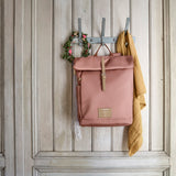 The Lassig rolltop nappy change backpack in cinnamon, hanging on a coat hook